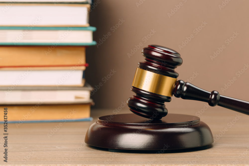 Judge gavel and laws books on a wooden table.