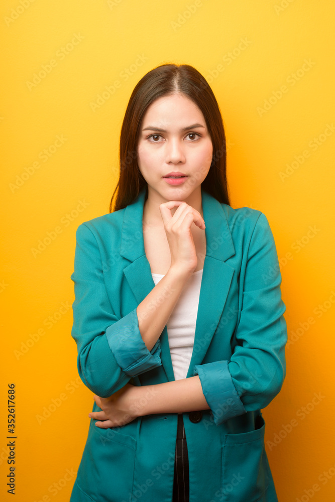 portrait of beautiful business woman in green suit on yellow background portrait of beautiful business woman in green suit on yellow background