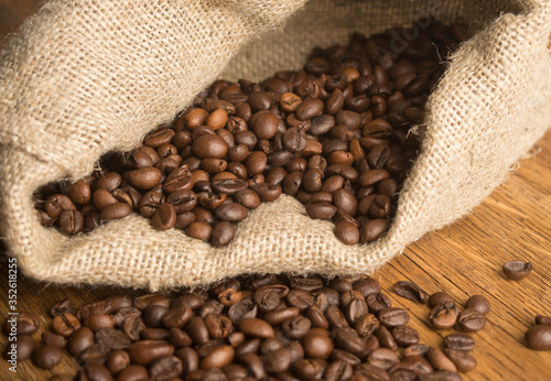 Coffee beans in canvas sack on wooden table