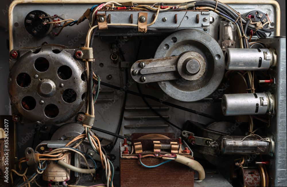 Obraz premium The internal mechanism of an old reel tape recorder with vacuum tubes, transformer, electric motor and other details.