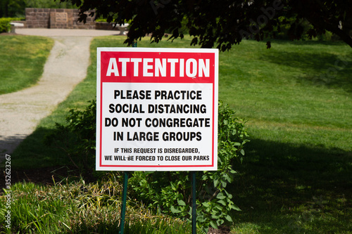 A park sign reminds park-goers to adhere to social guidelines put in place by the CDC as a result of covid-19.