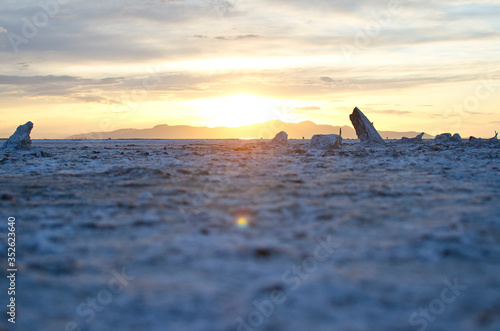 The glowing sunlight on the salty shores of the great salt lake in the utah desert landscape. 