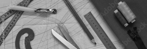 on a paper pattern are tailor's scissors, pattern, ruler, pencil, thread, zipper and a piece of fabric