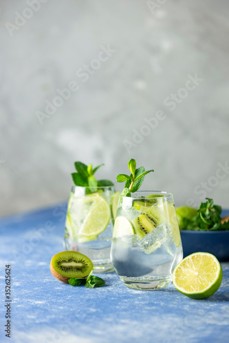 Two detox water or martini tonic cocktail with kiwi, lime, ice and mint. A new kind of mojito with kiwi, lime and mint and of course ice