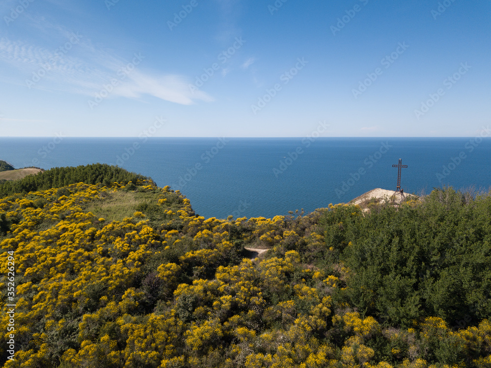 Italy, Pesaro 2020 - view of the cross of the san bartolo park on the cliff overlooking the sea with gorse and paths for trekking and mountain biking