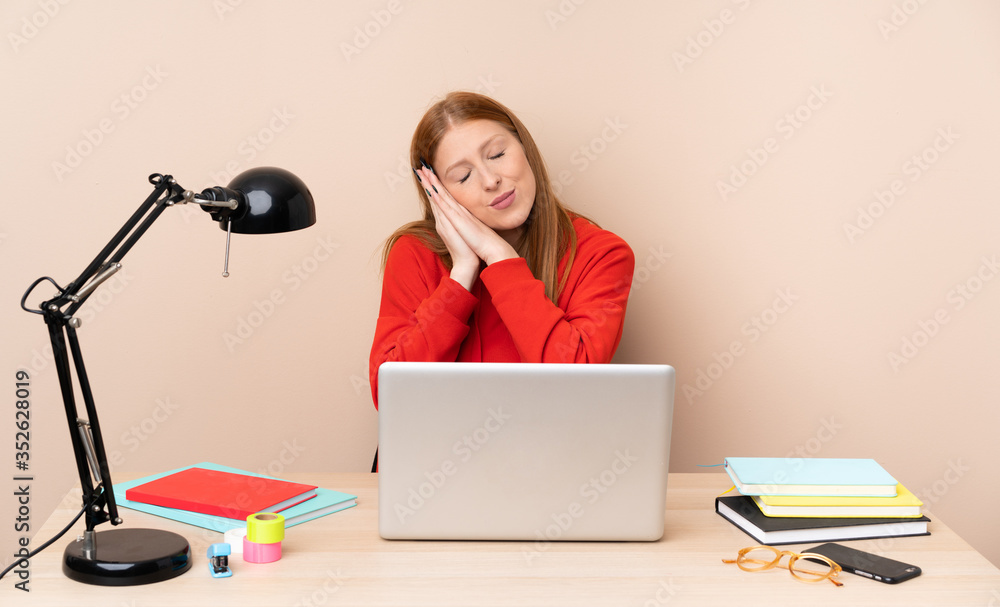 Young student woman in a workplace with a laptop making sleep gesture in dorable expression Young student woman in a workplace with a laptop making sleep gesture in dorable expression