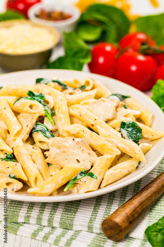 Chicken Alfredo with Spinach on Wooden Background. Selective focus. Chicken Alfredo with Spinach on Wooden Background. Selective focus.