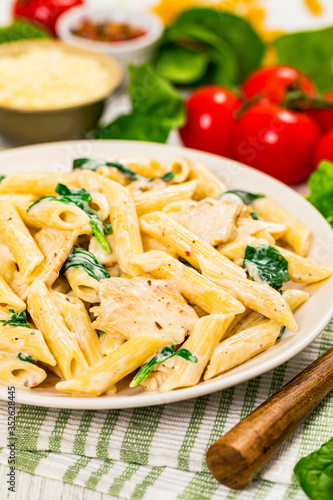 Chicken Alfredo with Spinach on Wooden Background. Selective focus.