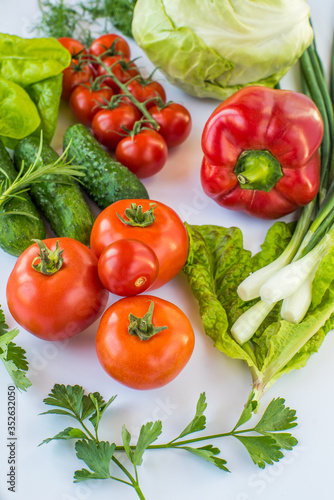 different types of vegetables on a white background top view. vegan products. peppers, cabbage, tomatoes, cucumbers, various herbs. vegetable diet.