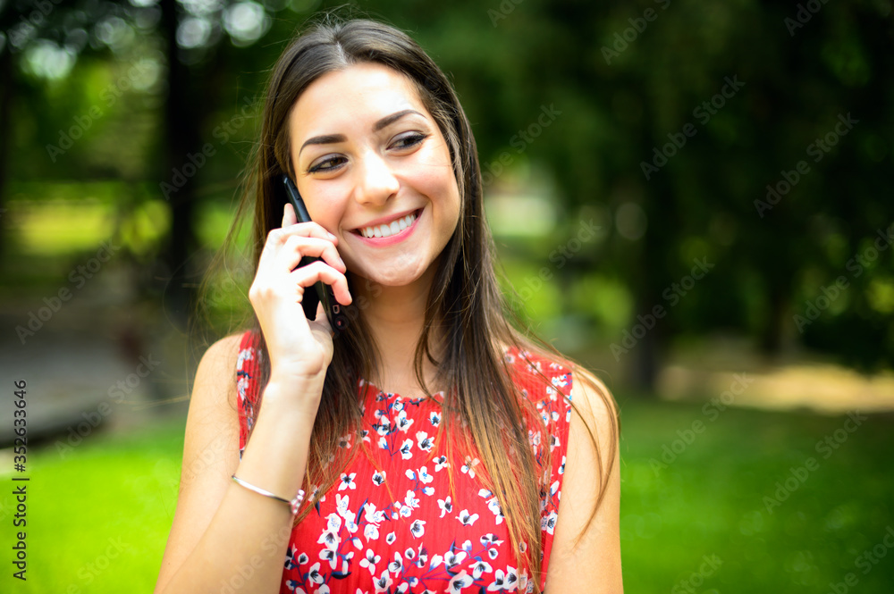 Young beautiful woman on the phone in a park Young beautiful woman on the phone in a park