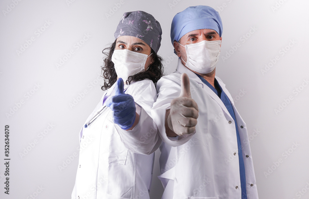 Male and female doctor doing victory sign with his hand on the screen. Male and female doctor doing victory sign with his hand on the screen.