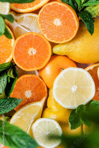 Fototapeta Naklejka Na Ścianę i Meble -  Citruses. Oranges, lemons, Limes, tangerines are scattered on the table. The sun's rays illuminate the fruit.