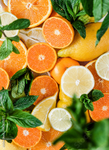 Fototapeta Naklejka Na Ścianę i Meble -  Citruses. Oranges, lemons, Limes, tangerines are scattered on the table. The sun's rays illuminate the fruit.