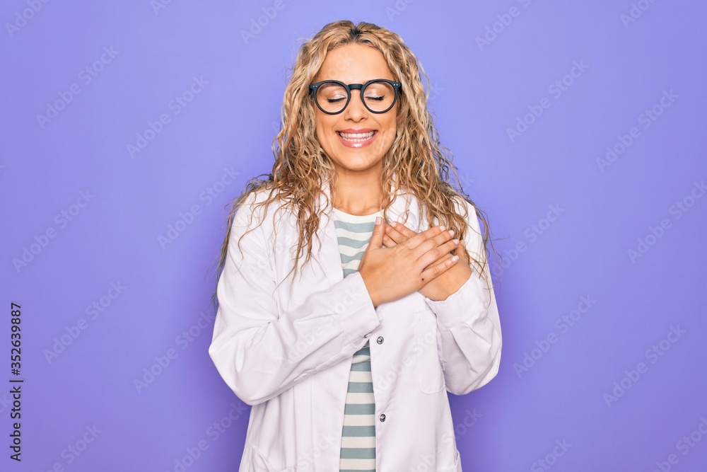 Young beautiful blonde scientist woman wearing coat and glasses over purple background smiling with hands on chest with closed eyes and grateful gesture on face. Health concept. Young beautiful blonde scientist woman wearing coat and glasses over purple background smiling with hands on chest with closed eyes and grateful gesture on face. Health concept.
