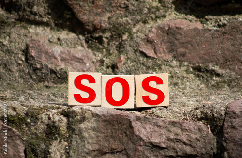 Wooden blocks forming the letters SOS isolated on white background