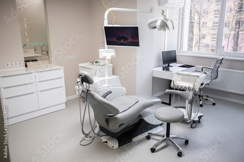 Fototapeta Naklejka Na Ścianę i Meble -  Modern Dental Clinic, Dentist chair and other accessories used by dentists in medical light. Dental surgeon, is a surgeon . Dentist's office. Dental equipment in modern, clean interior