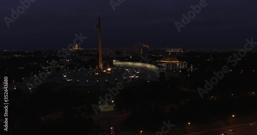 4K early night aerial video of busy road traffic with background view of high-rise buildings and memorial complex in Moscow, Russia