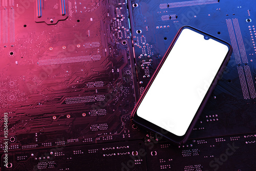 Smartphone frame less blank screen on computer motherboard tecnologic background. Mockup generic device.Template for infographics or presentation.Top view photo