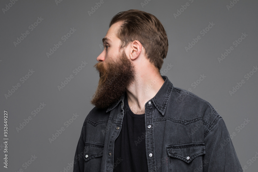 Handsome bearded young hipster man isolated on gray background Handsome bearded young hipster man isolated on gray background