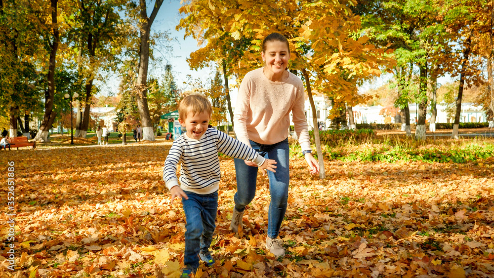 Happy laughing family running and palying at autumn park Happy laughing family running and palying at autumn park