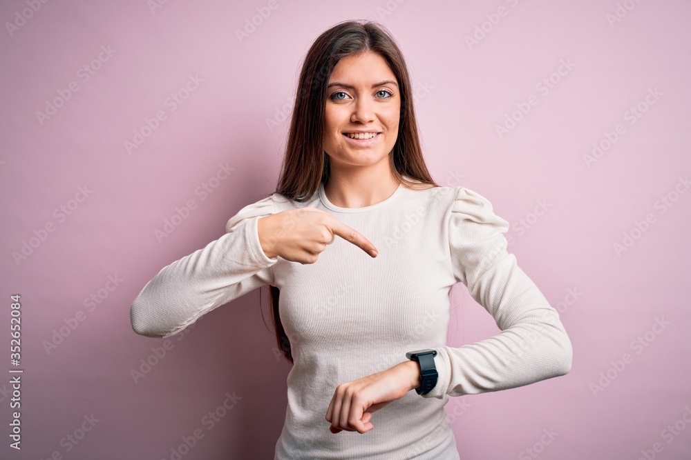 Young beautiful woman with blue eyes wearing casual white t-shirt over pink background In hurry pointing to watch time, impatience, upset and angry for deadline delay Young beautiful woman with blue eyes wearing casual white t-shirt over pink background In hurry pointing to watch time, impatience, upset and angry for deadline delay