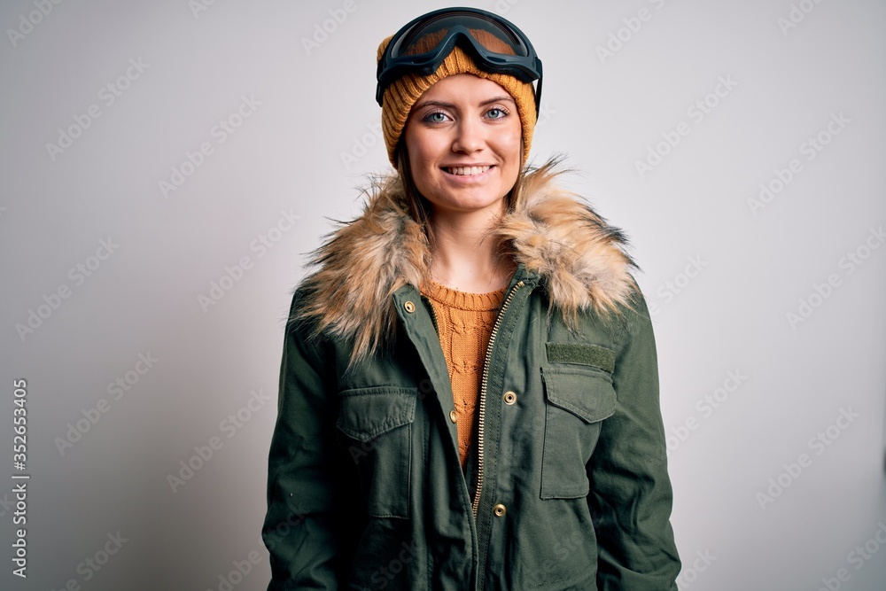 Young beautiful skier woman with blue eyes wearing snow sportswear and ski goggles with a happy and cool smile on face. Lucky person. Young beautiful skier woman with blue eyes wearing snow sportswear and ski goggles with a happy and cool smile on face. Lucky person.