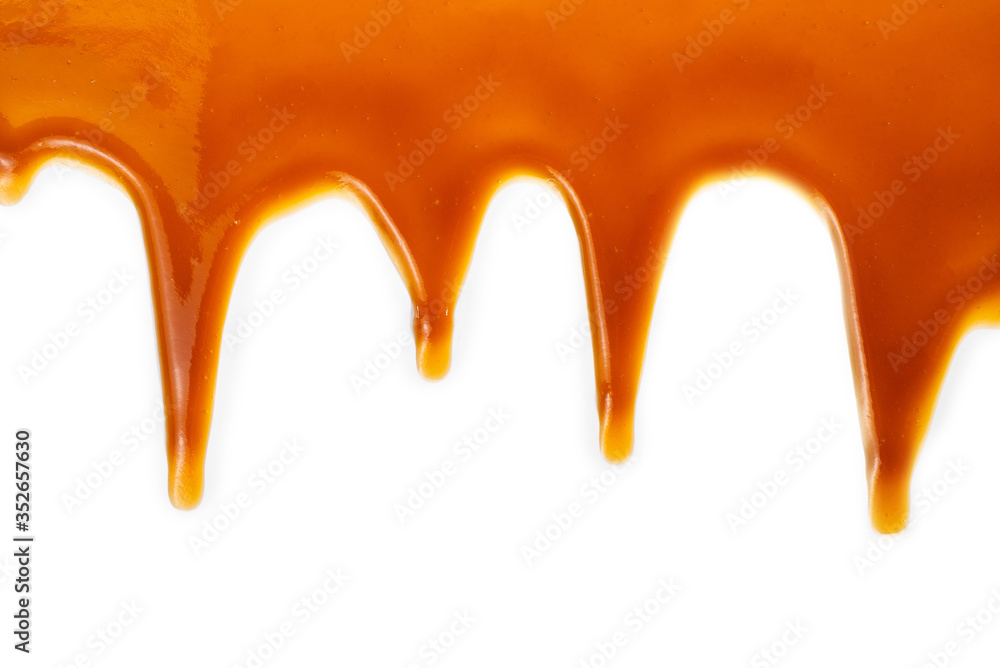 Background of flowing caramel sauce isolated on white.