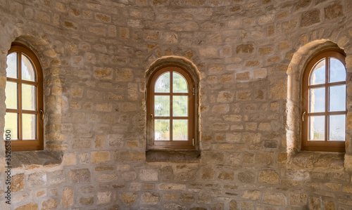 Drei sanierte Sprossenfenster in einer Natursteinmauer eingefasst