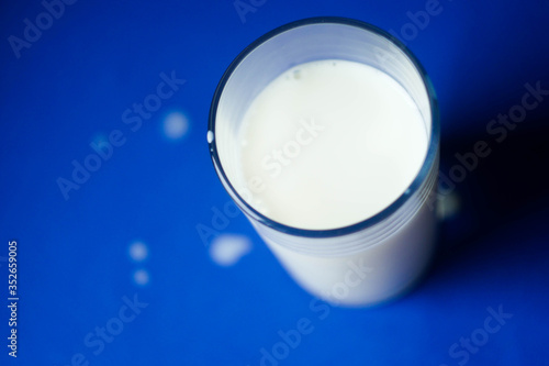 Top view glass of mils with drops on table. Copy space. International milk day. Calcium products 