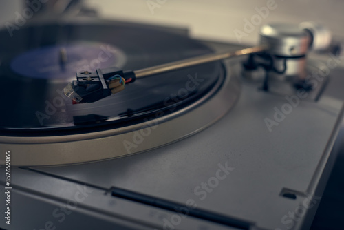 The vinyl needle reads the music from the record on a vinyl player. Old school. musical atmosphere. Old player and analog music. subject photo. song plays