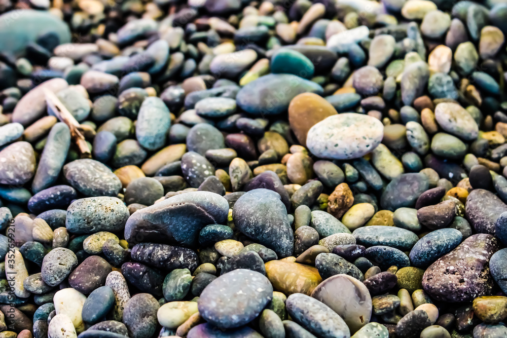 Small sea stones on the beach with different textures Small sea stones on the beach with different textures