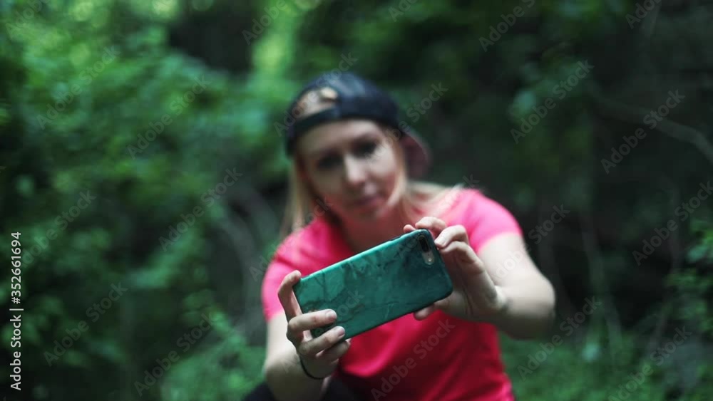 A young woman takes photos and videos with her cell phone camera A young woman takes photos and videos with her cell phone camera