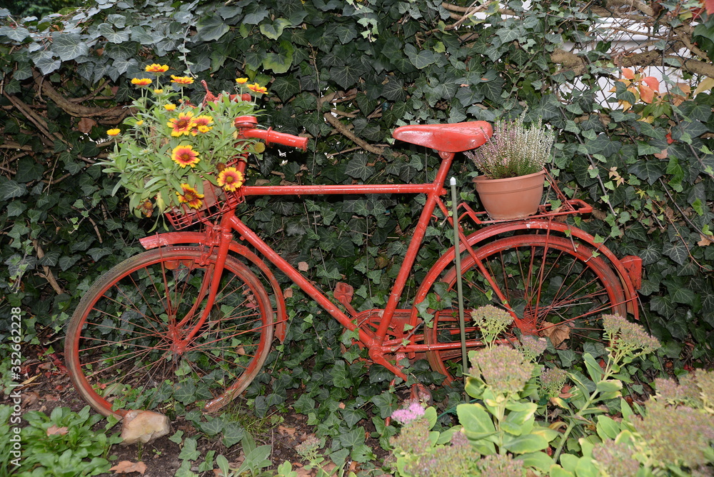 Rotes Fahrrad mit Blumenschmuck