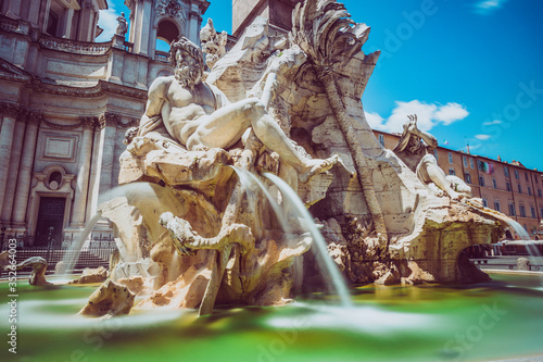 Fountain of rivers in Rome in Italy. In the background, the baroque church of Santa Agnese in Agone. Blue sky. photo