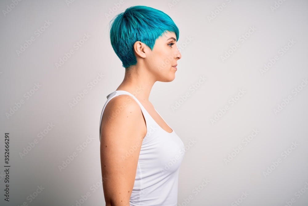 Young beautiful woman with blue fashion hair wearing casual t-shirt over white background looking to side, relax profile pose with natural face and confident smile. Young beautiful woman with blue fashion hair wearing casual t-shirt over white background looking to side, relax profile pose with natural face and confident smile.