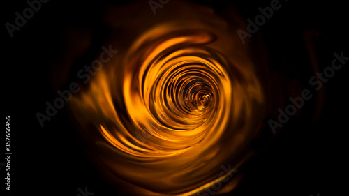 Smooth orange vortex. Whirlpool, water swirl, top view. High speed liquid photography.