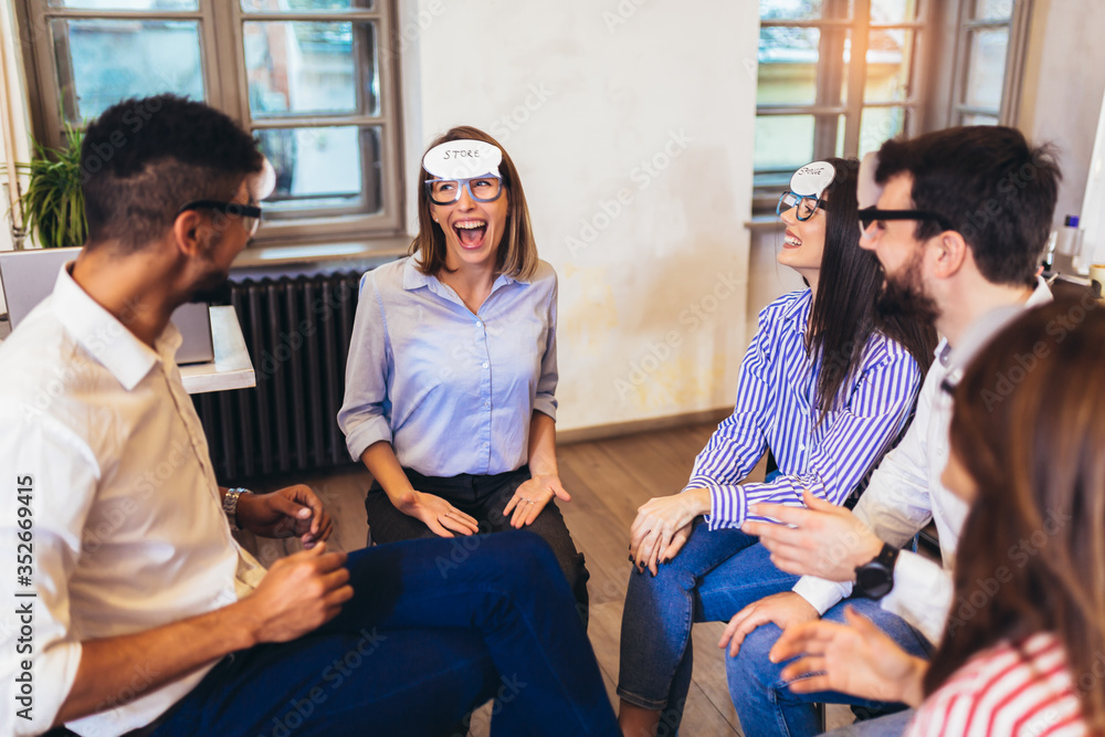 Happy friendly business team having fun at corporate training, funny teambuilding activity, playing game guess who. Happy friendly business team having fun at corporate training, funny teambuilding activity, playing game guess who.