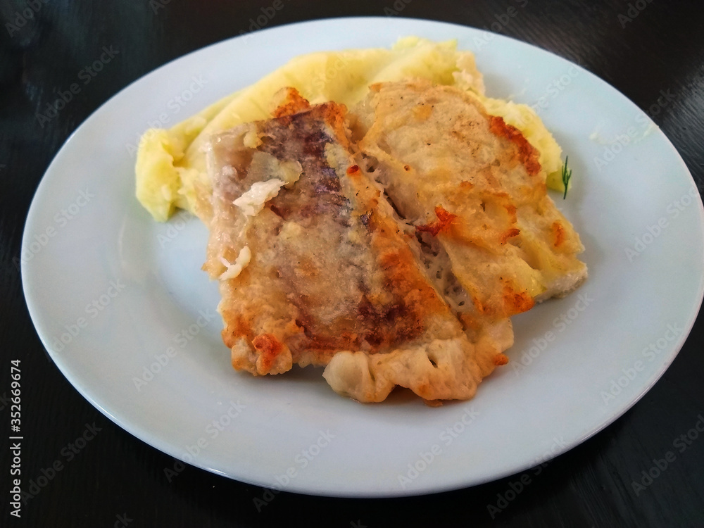 fried fish with golden brown crust and mashed potatoes on a white plate fried fish with golden brown crust and mashed potatoes on a white plate