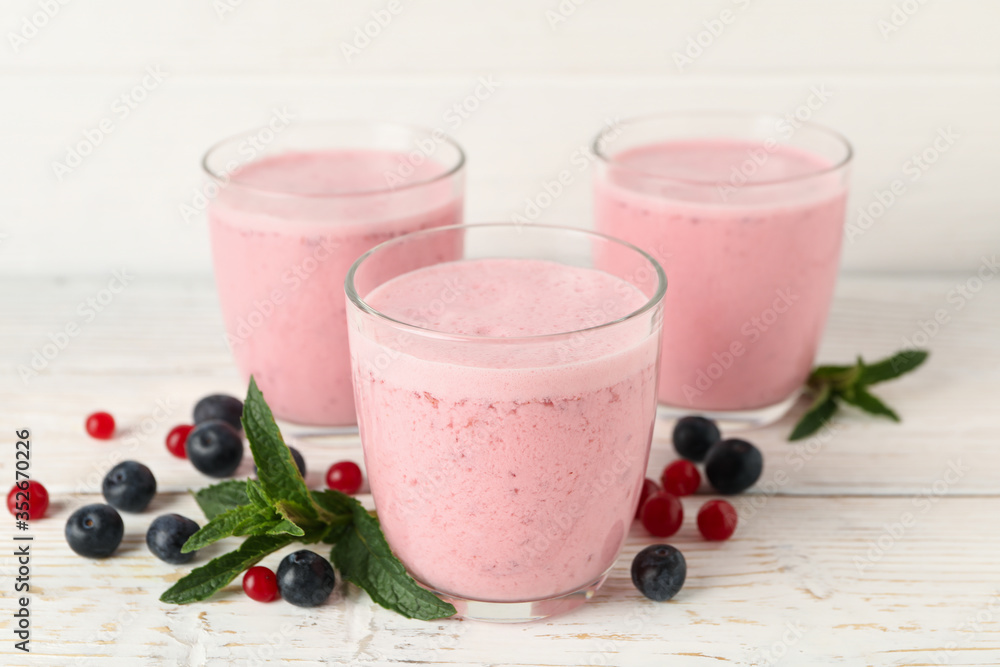 Delicious berry milkshakes on wooden table. Summer drink Delicious berry milkshakes on wooden table. Summer drink