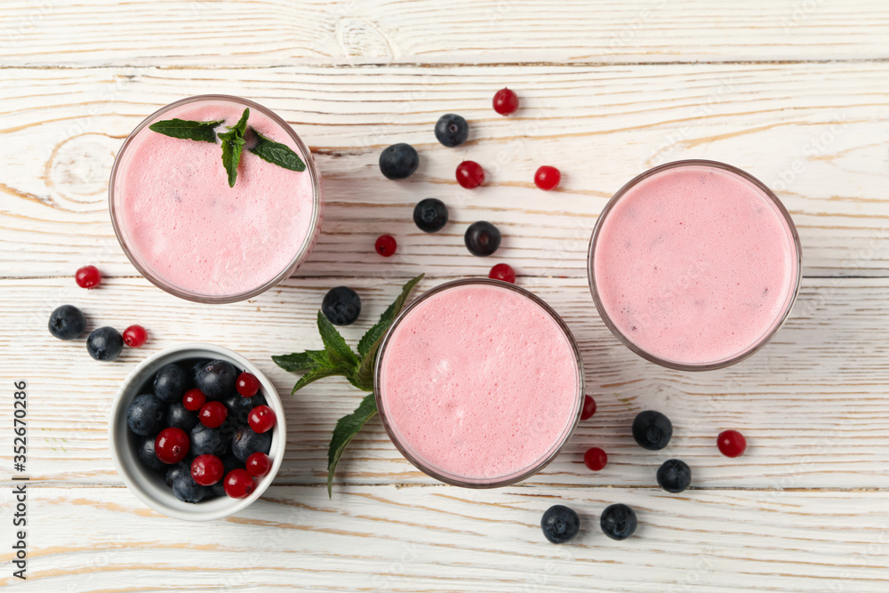 Delicious berry milkshakes on wooden table. Summer drink