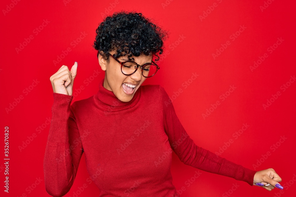 Young beautiful african american afro woman wearing turtleneck sweater and glasses Dancing happy and cheerful, smiling moving casual and confident listening to music Young beautiful african american afro woman wearing turtleneck sweater and glasses Dancing happy and cheerful, smiling moving casual and confident listening to music