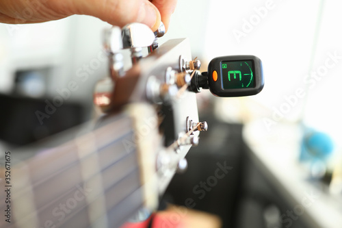 Foto Tuner is installed on guitar neck for tuning notes
