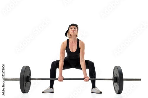 Young woman doing deadlift with a barbell isolated on white. Front view