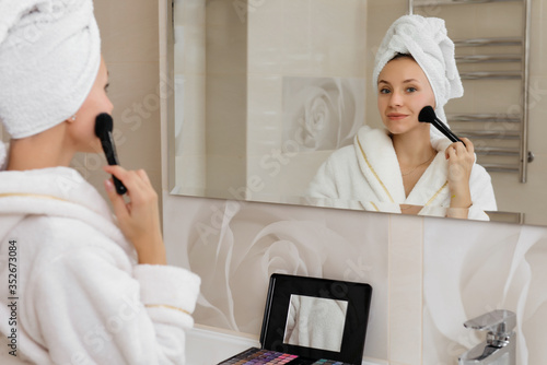 Woman doing herself makeup at home in the bathroom