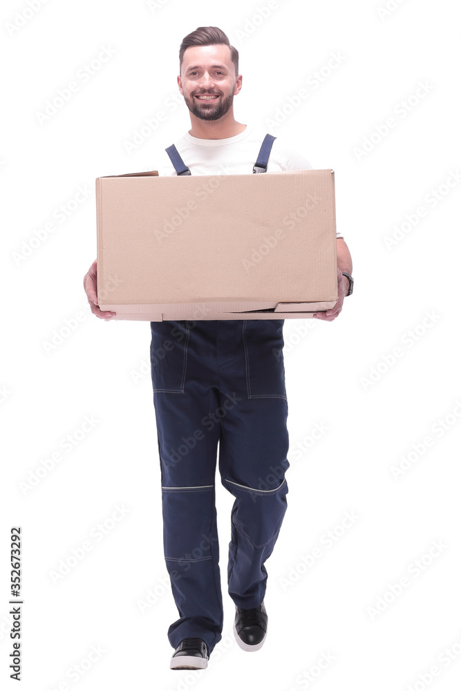 in full growth. smiling man carries a large cardboard box in full growth. smiling man carries a large cardboard box