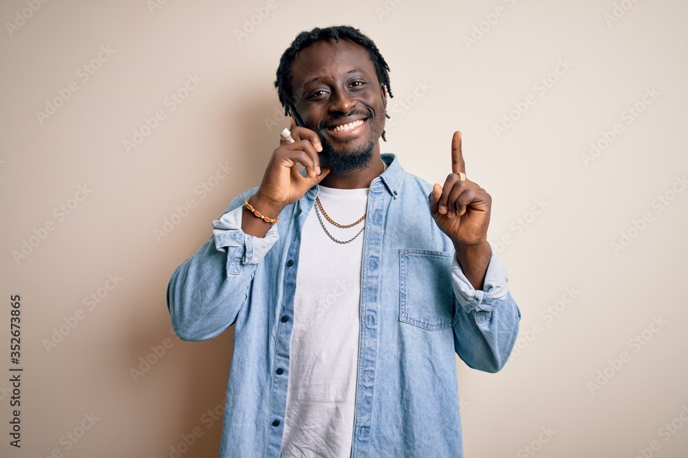 African american man having conversation talking on the smartphone over white background surprised with an idea or question pointing finger with happy face, number one African american man having conversation talking on the smartphone over white background surprised with an idea or question pointing finger with happy face, number one