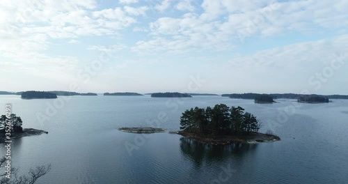 Aerial view flying over islands in uusimaa saaristo archipelago, on the gulf of finland, on a sunny morning. photo