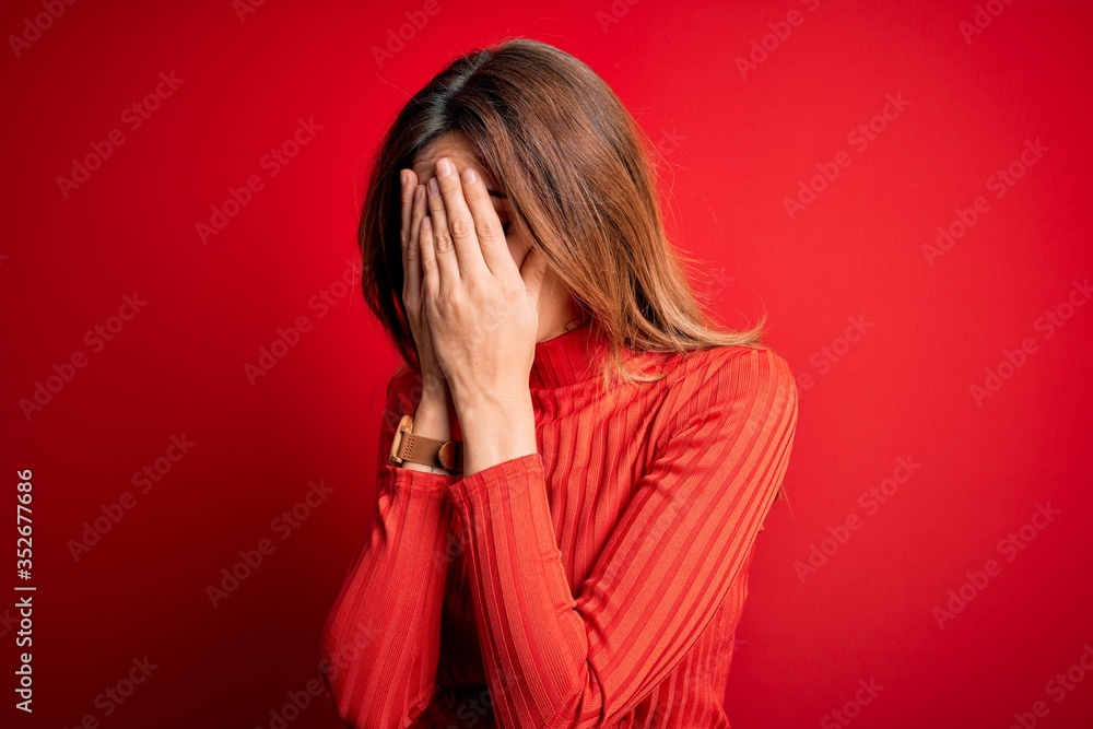 Young beautiful brunette woman wearing casual turtleneck sweater over red background with sad expression covering face with hands while crying. Depression concept. Young beautiful brunette woman wearing casual turtleneck sweater over red background with sad expression covering face with hands while crying. Depression concept.