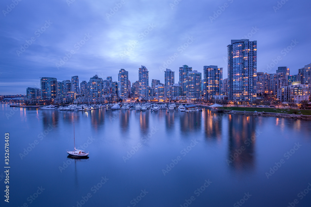 Obraz premium Vancouver downtown architecture and boat with water reflections at dusk