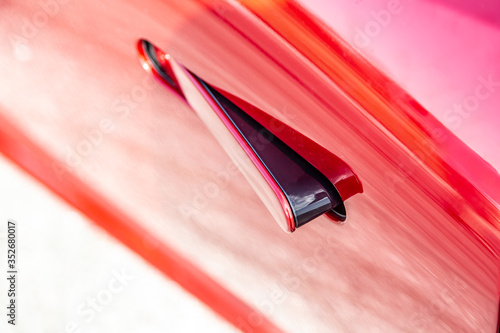 Modern door handle on a red car. Close-up. Horizontal orientation. 